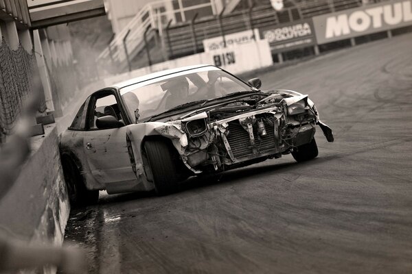 Black and white photo of the car after the accident on the race track