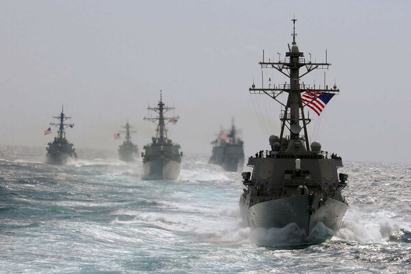 Kriegsschiffe unter US-Flagge in einem vom Wind berauschenden Meer