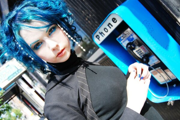 The girl with blue hair near the phone