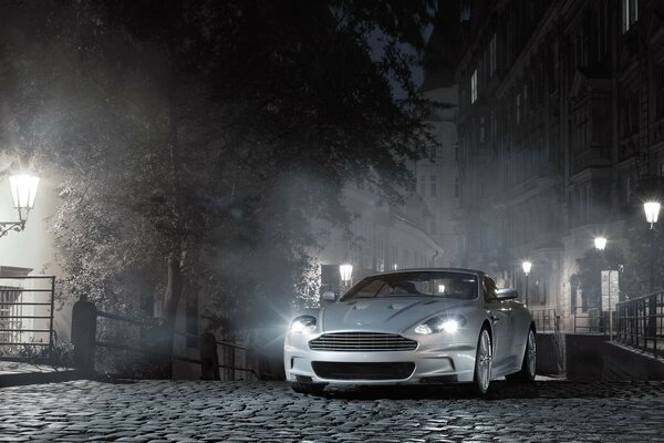 Aston Martin dans une rue de nuit brumeuse