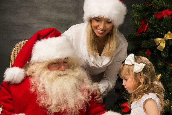 Una niña con papá Noel y una doncella de nieve