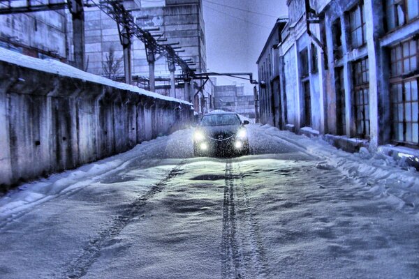 Paisaje de invierno con un Mazda blanco que enciende los faros