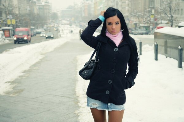 Chica de pie en medio de las calles cubiertas de nieve