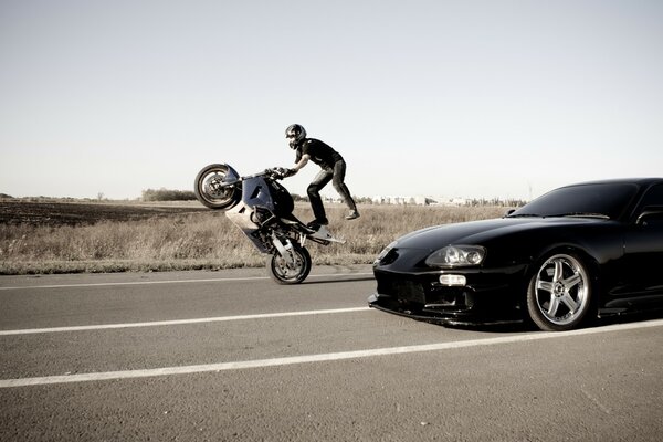 Stuntman overtakes Toyota on a motorcycle