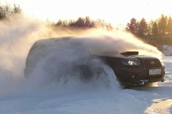 Sur une piste enneigée, une Subaru noire peine à traverser la neige