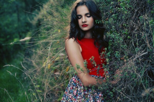 Brunette in a red T-shirt by a tree