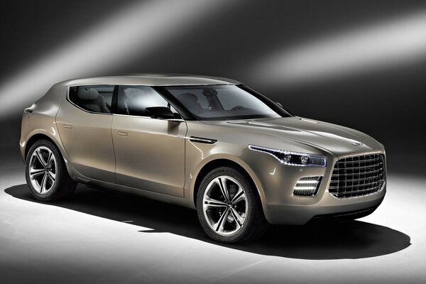 Aston Martin Lagonda Concept pod jasnymi podsufitkami na szarym tle