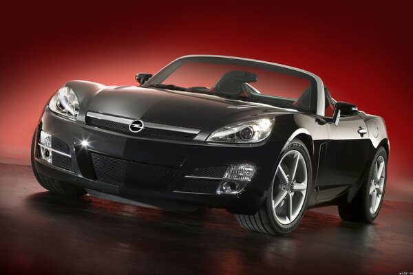 Opel convertibile nero su sfondo rosso