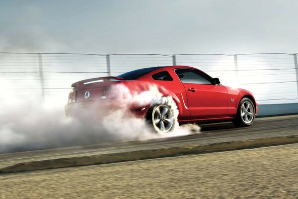 Ford mustang rouge dans la fumée de ses propres roues