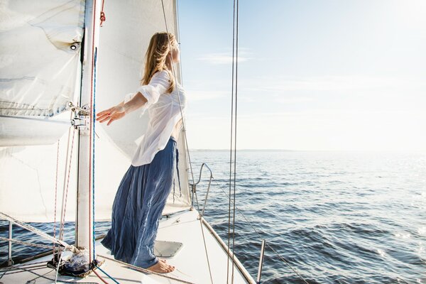 Una ragazza su uno yacht naviga per incontrare il vento