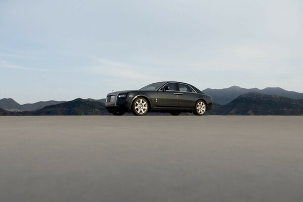 Black Rolls Royce on the background of the rocky mountains