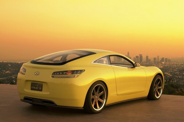 Yellow hyundai sports car on the background of the city