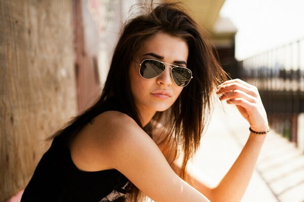 Foto contra el viento. Chica en gafas de sol