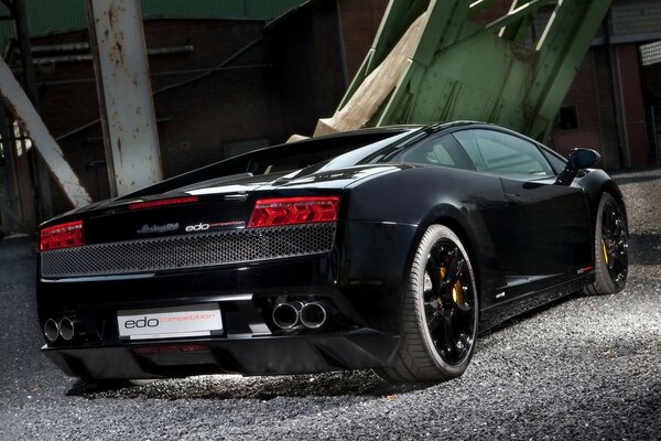 A black Lamborghini on the street. Rear view