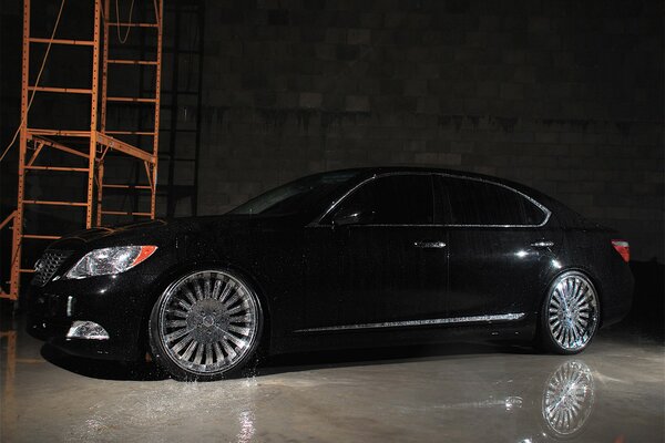 Schwarzer Lexus, der mit Wasser im Hangar bedeckt ist