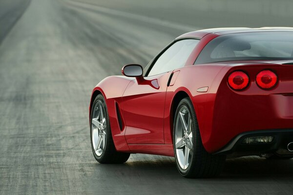 Un Chevrolet Corvette rojo se encuentra en la carretera