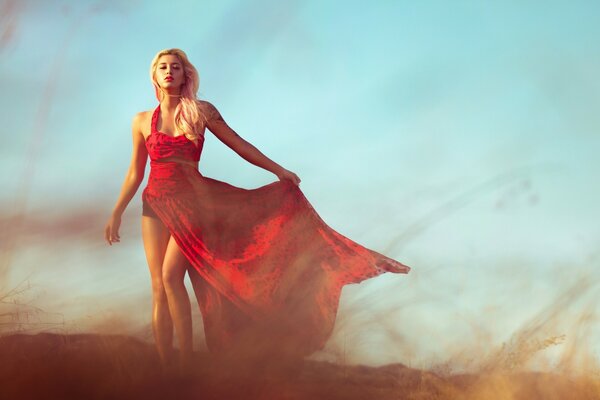 A girl in a beautiful red dress with a train