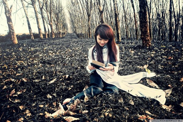 Foto autunnale nel boschetto. Ragazza con il libro