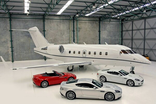 An airplane and three cars indoors