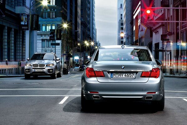 A grey BMW is standing at a traffic light