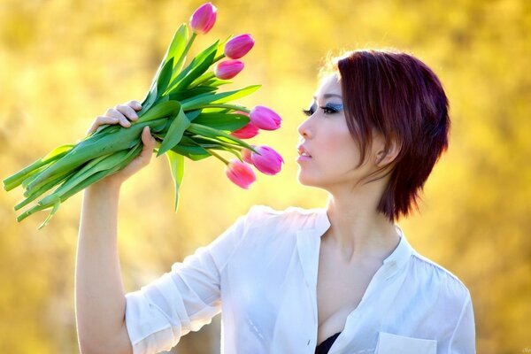 Brune aux cheveux courts avec un bouquet de tulipes