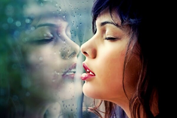 Brunette respirant sur le verre par temps de pluie