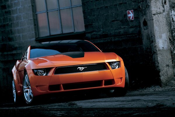 Der Mustang Orange in der Gasse steht