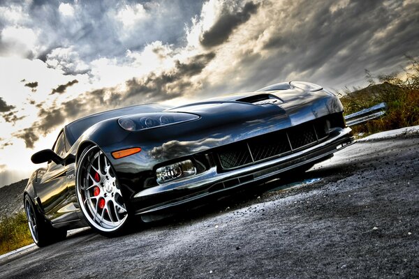 Chevrolet corvette on gray asphalt, car under a cloudy sky