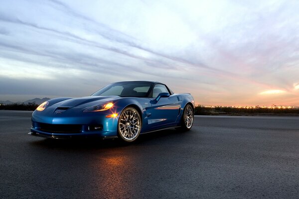 Blaues Auto auf Sonnenuntergang Hintergrund