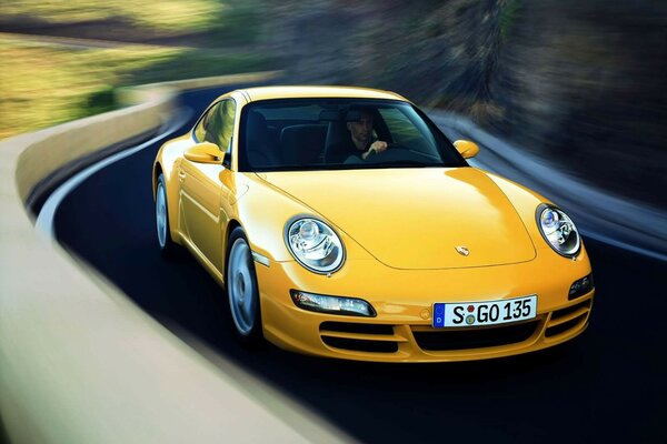 Yellow Porsche 911 on a mountain road