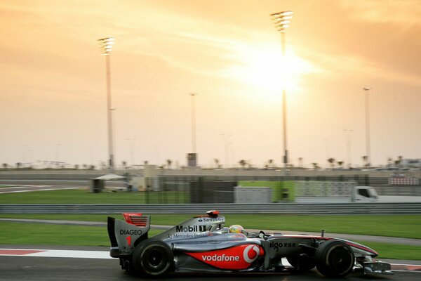 Formula one car on the track at sunset