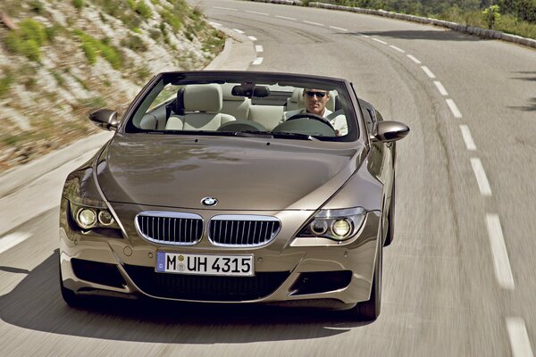 BMW brun sur une route vallonnée
