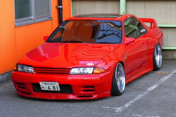 A red car on the background of an orange wall