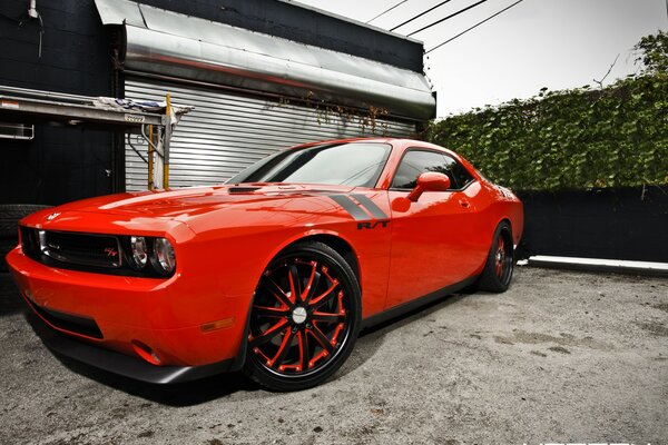 Red challenger tuning near the garage