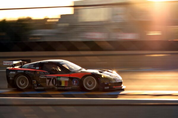 Voiture de sport sur la piste, au coucher du soleil