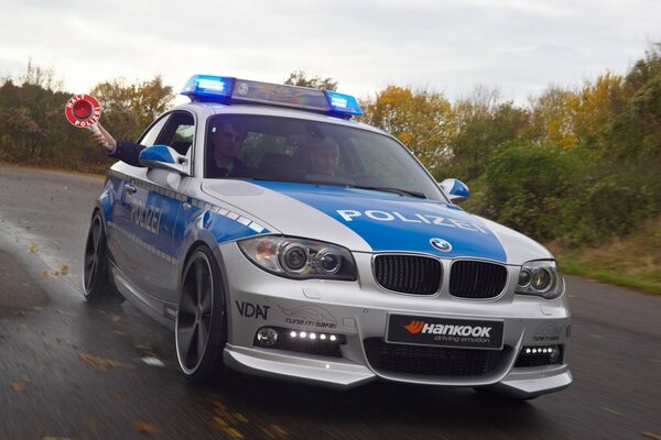 Coche de policía gris y azul en Autumn Road