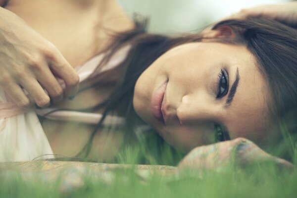 Visage d une jeune fille brune allongée sur l herbe. Macro