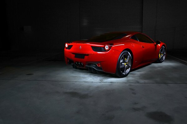 Ein roter ferrari 458 italia fährt in die Garage