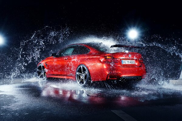 Shiny BMW m4 with splashes from under the wheels