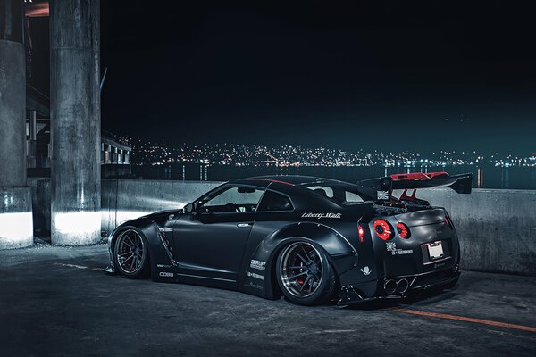 Nissan sportiva grigia sullo sfondo della città notturna