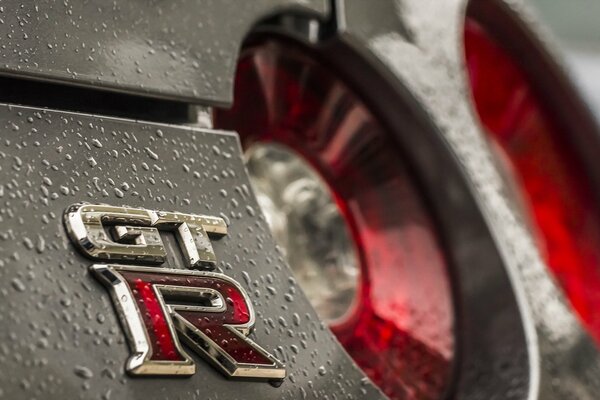 Fotografía macro de la insignia Gt-r con gotas de lluvia