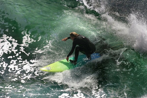 Surfista en agua verde en el mar