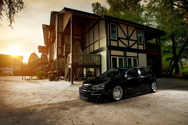 Black Volkswagen on the background of a dream house