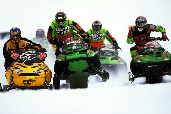 Racing athletes on snowmobiles in helmets