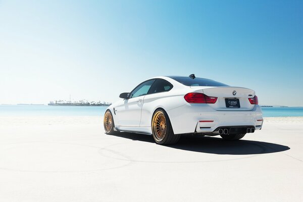 BMW sur le sable blanc de la plage de la mer noire