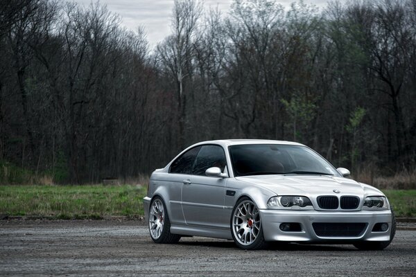 Silver BMW in the spring rainy forest