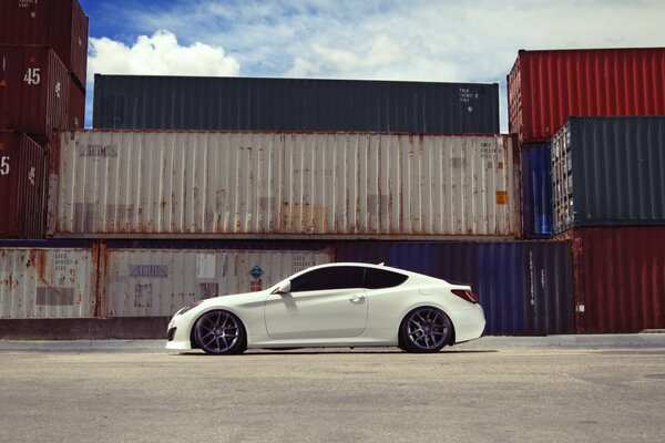 White Hyundai coupe beckons to the container