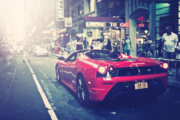 Automobile di Ferrari nel colore rosso sulla via della città