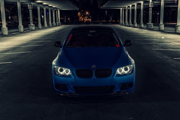 Un BMW azul está parado en el estacionamiento
