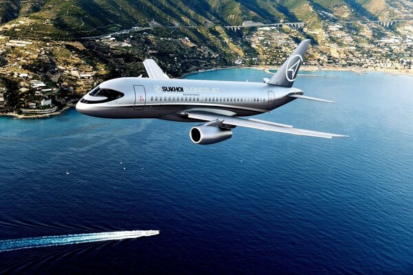 Superjet 100 in the sky flies over the most beautiful bay